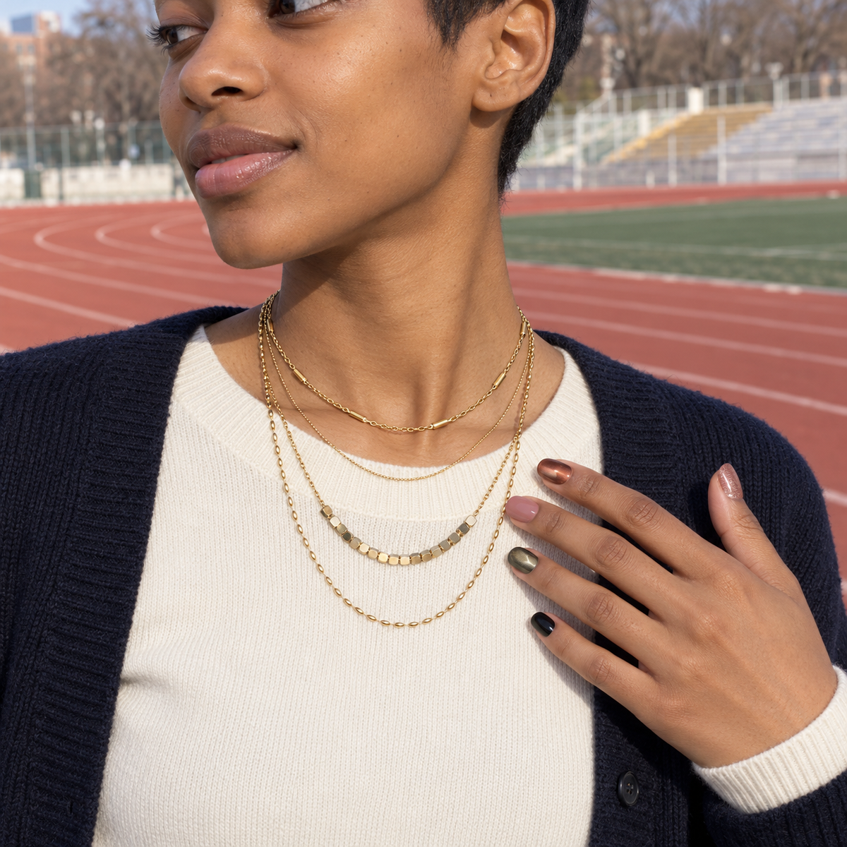 Set 03: model wearing the same layered jewelry and matching nails on her fingers.